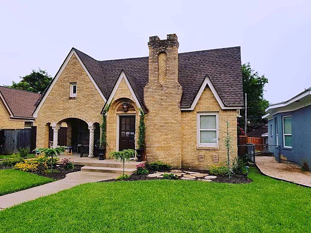Tudor brick home with a new Barkwood shingle roof and a cut lawn