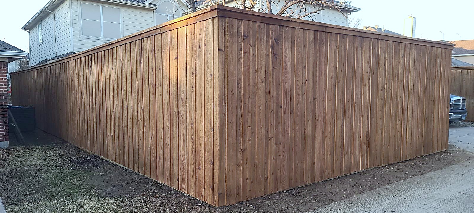 A new cedar fence corner installed by Reveles Roofing
