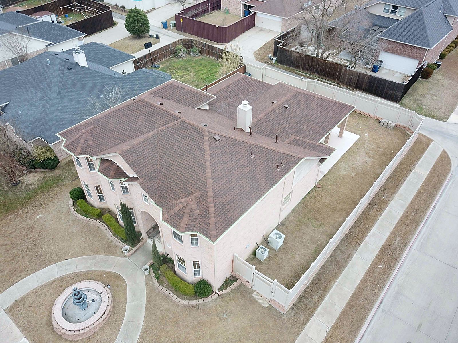 Aerial view of a brick home with a new Hickory shingle roof