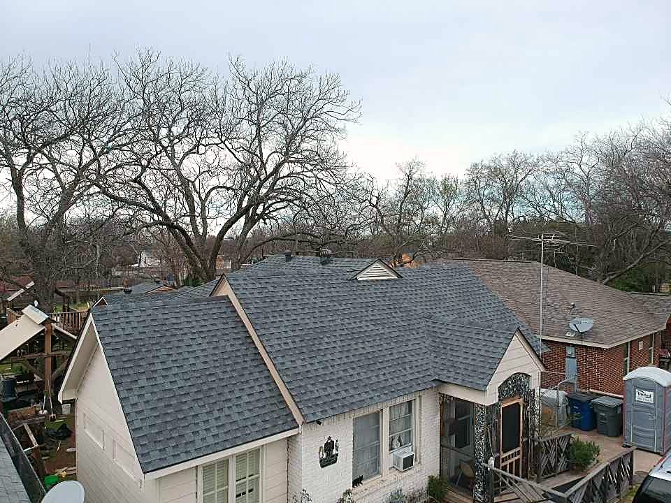 A Dallas home with a finished pewter gray shingle roof, seen from the street